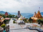 Colorful hilltop temple complex with mountain backdrop